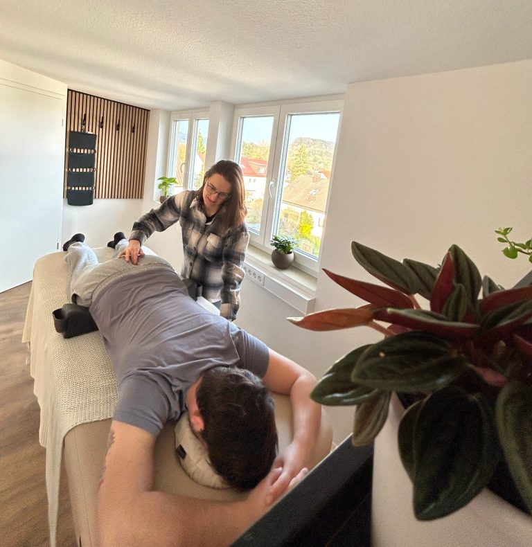 Eine Person erhält von Franziska eine Spinalflow Einheit in einem ruhigen Raum. Die Person liegt dabei auf einer hellen Spinalflow Liege. Eine Person erhält von Franziska eine Spinalflow Einheit in einem ruhigen Raum. Die Person liegt dabei auf einer hellen Spinalflow Liege.